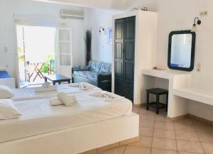 a bedroom with a large bed and a tv at Agios Pavlos Studios in Aegiali