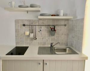 a kitchen with a sink and a counter top at Agios Pavlos Studios in Aegiali