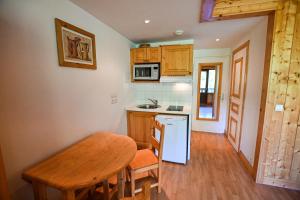 une cuisine avec une table en bois, une table et un comptoir dans l'établissement LUMINEUX studio avec BALCON à Combloux !, à Combloux