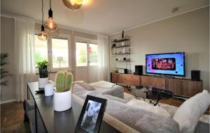 a living room with a couch and a tv at Amazing Home In Aln With Wifi And 3 Bedrooms in Sundsbruk