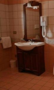 La salle de bains est pourvue d'un lavabo et d'un miroir. dans l'établissement MARCHESINA RESORT srls, à Teggiano