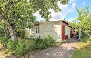 a small white and red house with a tree at Amazing Home In Aln With Wifi And 3 Bedrooms in Sundsbruk