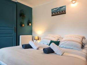 1 dormitorio con 1 cama con almohadas azules y blancas en La Vicomté - Quai Henri IV - WIFI gratuit, en Dieppe