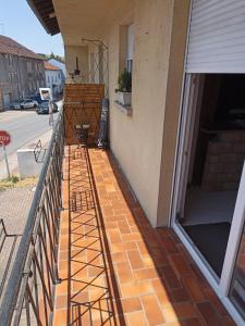 einen Balkon eines Hauses mit Backsteinboden in der Unterkunft appartement avec balcon in Hargarten-aux-Mines