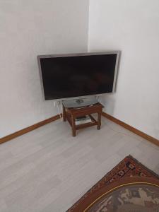 einen Flachbild-TV in einem Zimmer mit einem Tisch in der Unterkunft appartement avec balcon in Hargarten-aux-Mines