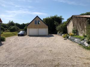 a barn with a car parked in a driveway at Chambre d'hôtes Boutteville in Boutteville