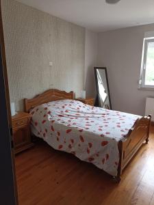 1 Schlafzimmer mit einem Bett mit Blumendecke in der Unterkunft appartement avec balcon in Hargarten-aux-Mines