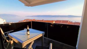 eine Flasche Wein auf dem Tisch auf dem Balkon in der Unterkunft Villa Buba **** in Novi Vinodolski