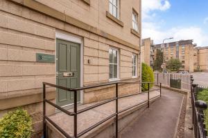 a balcony with a green door on a building at Modern City Centre 2 Bedroom 2 Bathroom Apartments, Main Door Ground with Private Parking in Edinburgh