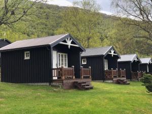 a row of black huts in a field at Solvang World Heritage Camping in Eidsdal