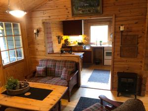 a living room with a couch and a table in a cabin at Solvang World Heritage Camping in Eidsdal