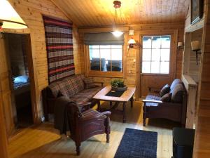 a living room with a couch and a table in a cabin at Solvang World Heritage Camping in Eidsdal