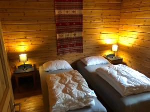 two beds in a room with two lamps on tables at Solvang World Heritage Camping in Eidsdal