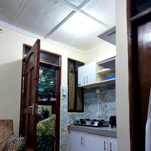 Amarossi Hippo-Studio Terrace Apartment, Mtwapa في متوابا: مطبخ بدولاب بيضاء وموقد