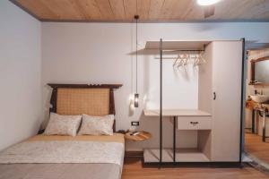 1 dormitorio pequeño con 1 cama y pared de cristal en Krassopsychia Apartments en Krásion