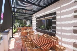 a patio with a wooden table and chairs at Hotel Posada Terranova in San José del Cabo