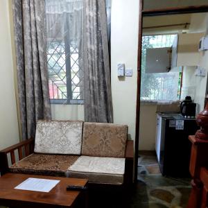 Amarossi Hippo-Studio Terrace Apartment, Mtwapa في متوابا: غرفة معيشة مع أريكة وطاولة