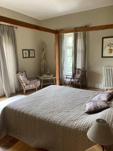 a bedroom with a large bed and two chairs at Chateau Tout Y Fault in Loriges