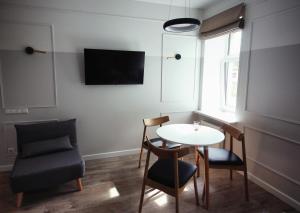 Cette petite chambre dispose d'une table, de chaises et d'une télévision. dans l'établissement Comfortable design apartment on Vilanu, à Riga