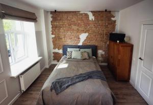 - une chambre avec un lit et un mur en briques dans l'établissement Comfortable design apartment on Vilanu, à Riga