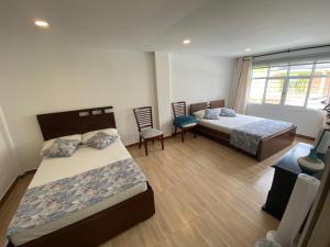 una camera da letto con due letti, un tavolo e delle sedie di Hotel Encanto Filandia a Filandia Altre 10 foto