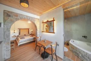 Schlafzimmer mit einem Bett, einem Tisch und einer Badewanne in der Unterkunft Krassopsychia Apartments in Krásion