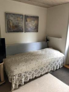 a bed in a bedroom with two pictures on the wall at Maren's apartment on Randbøl Heath in Randbøl