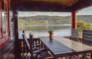 a table on a porch with a view of a lake at Bergheim in Vikersund