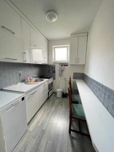 a kitchen with white cabinets and a sink and a counter at GOT Prishtina Hostel in Prishtinë