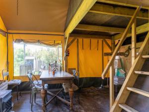 カラントスウオーフにあるWonderful Beach lodge for 8 people near beach sea and the village of Callantsoogの黄色い壁の客室で、木製テーブルが備わります。