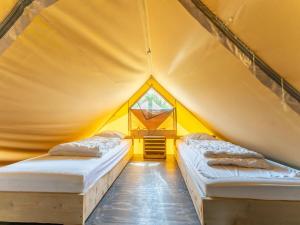 カラントスウオーフにあるWonderful Beach lodge for 8 people near beach sea and the village of Callantsoogの黄色のテント ベッド2台 窓付