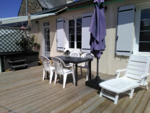 een patio met een tafel en stoelen en een parasol bij Emeraude Jacuzzi in Saint-Malo