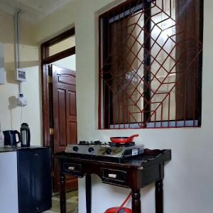 Amarossi Hippo-Studio Terrace Apartment, Mtwapa في متوابا: مطبخ مع موقد علوي في الغرفة