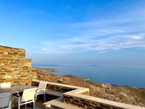 a patio with a table and chairs and the ocean at Dionysos Sea and Stone Luxury Villa in Kardiani