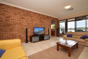 a living room with a brick wall and a television at Fishing Point Shores in Fishing Point