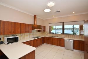 a kitchen with wooden cabinets and a large window at Fishing Point Shores in Fishing Point
