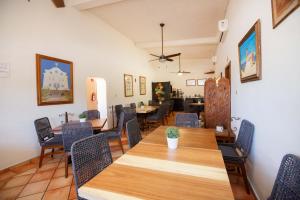 een eetkamer met een grote houten tafel en stoelen bij Hotel Posada Terranova in San José del Cabo