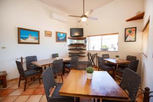 uma sala de jantar com mesas e cadeiras e uma televisão em Hotel Posada Terranova em San José del Cabo