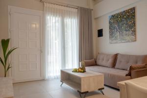 a living room with a couch and a table at Casale Luxury House - Luxury Garden Maisonettes in Nikiti