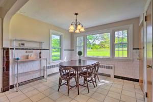 a kitchen with a table and chairs and windows at Cozy Middletown Home Near Beaches and Newport! in Middletown