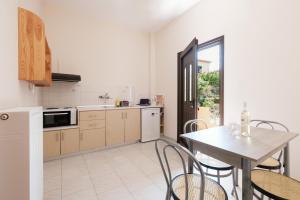 una cucina e una sala da pranzo con tavolo e sedie di Mouzakitis Apartments 3 a Arillas