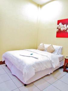 a bedroom with a bed with white sheets and pillows at Hotel Palmeras de Elim in Matagalpa