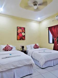 a bedroom with two beds and a painting on the wall at Hotel Palmeras de Elim in Matagalpa