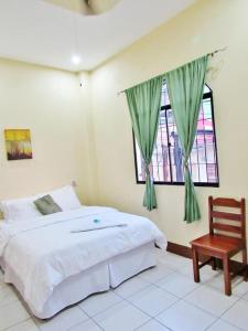 a bedroom with a bed and a chair and a window at Hotel Palmeras de Elim in Matagalpa