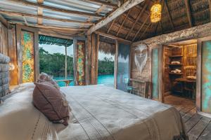 1 dormitorio con 1 cama grande en una habitación con ventanas en Embajada Universal By La Eufemia Group en Huay Pix