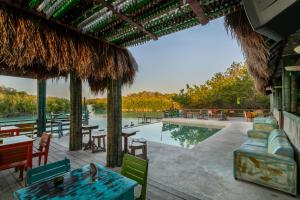 a resort with a pool and tables and chairs at Embajada Universal By La Eufemia Group in Huay Pix