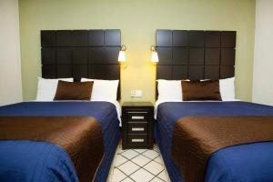2 camas en una habitación de hotel con camas azules y marrones en Hotel Posada Terranova en San José del Cabo