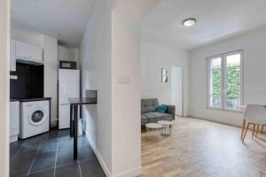 a white living room with a couch and a table at The New White Appart'Hôtel Vitry - Next to Paris in Vitry-sur-Seine