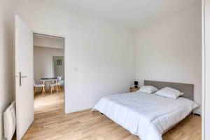 a white bedroom with a bed and a table at The New White Appart'Hôtel Vitry - Next to Paris in Vitry-sur-Seine