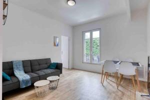 a living room with a couch and a table and chairs at The New White Appart'Hôtel Vitry - Next to Paris in Vitry-sur-Seine